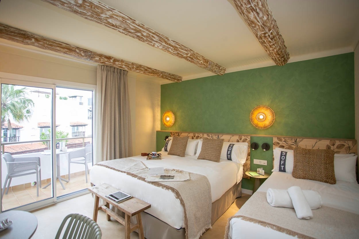 Chambre lumineuse avec lits jumeaux, balcon et mur vert chez Casual Bahía Ibiza - Hôtel près de la plage à Ibiza