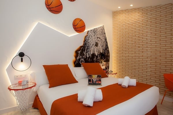 una habitación con una cama blanca y almohadas naranjas