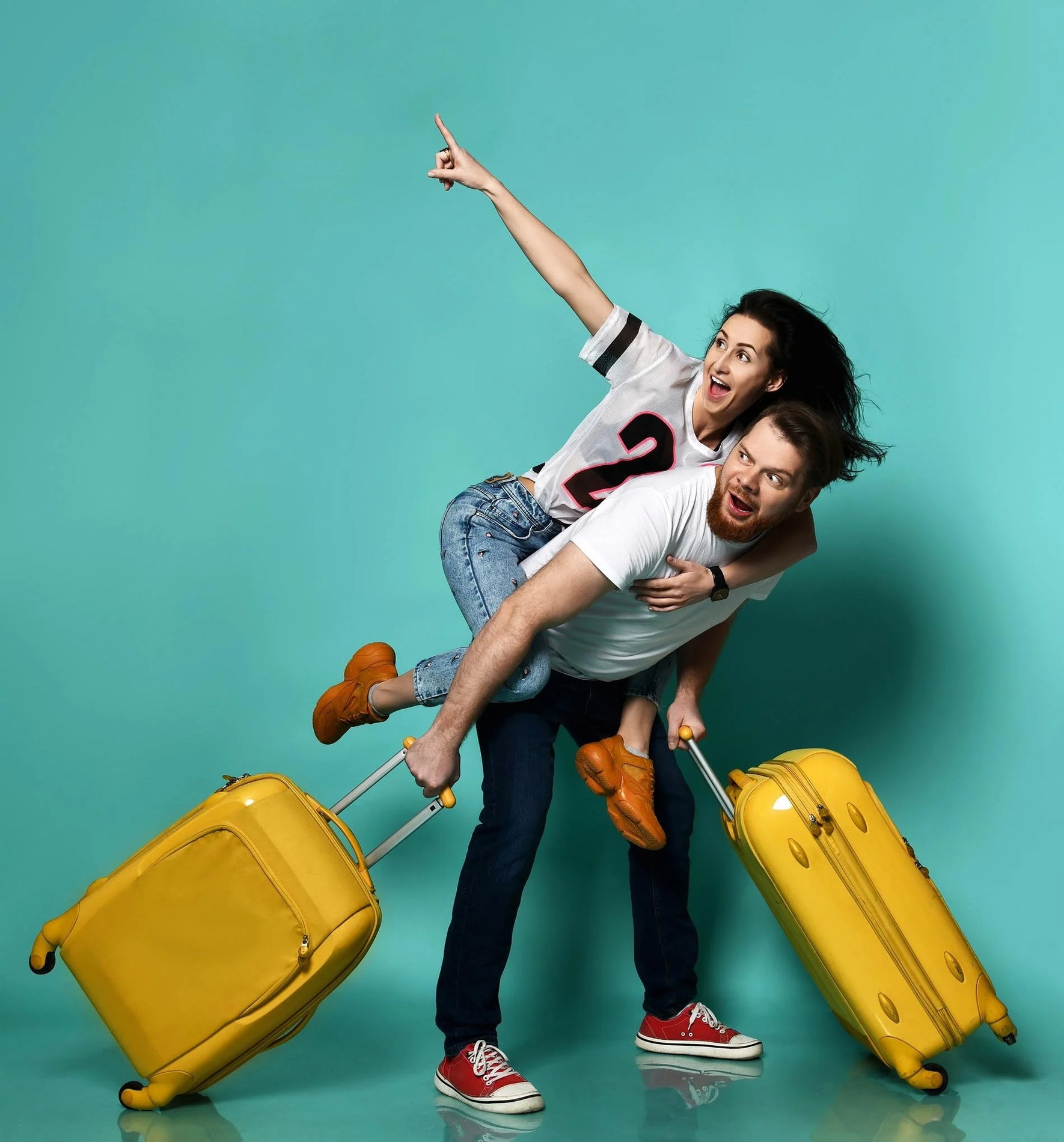 a man is carrying a woman on his back with a yellow suitcase