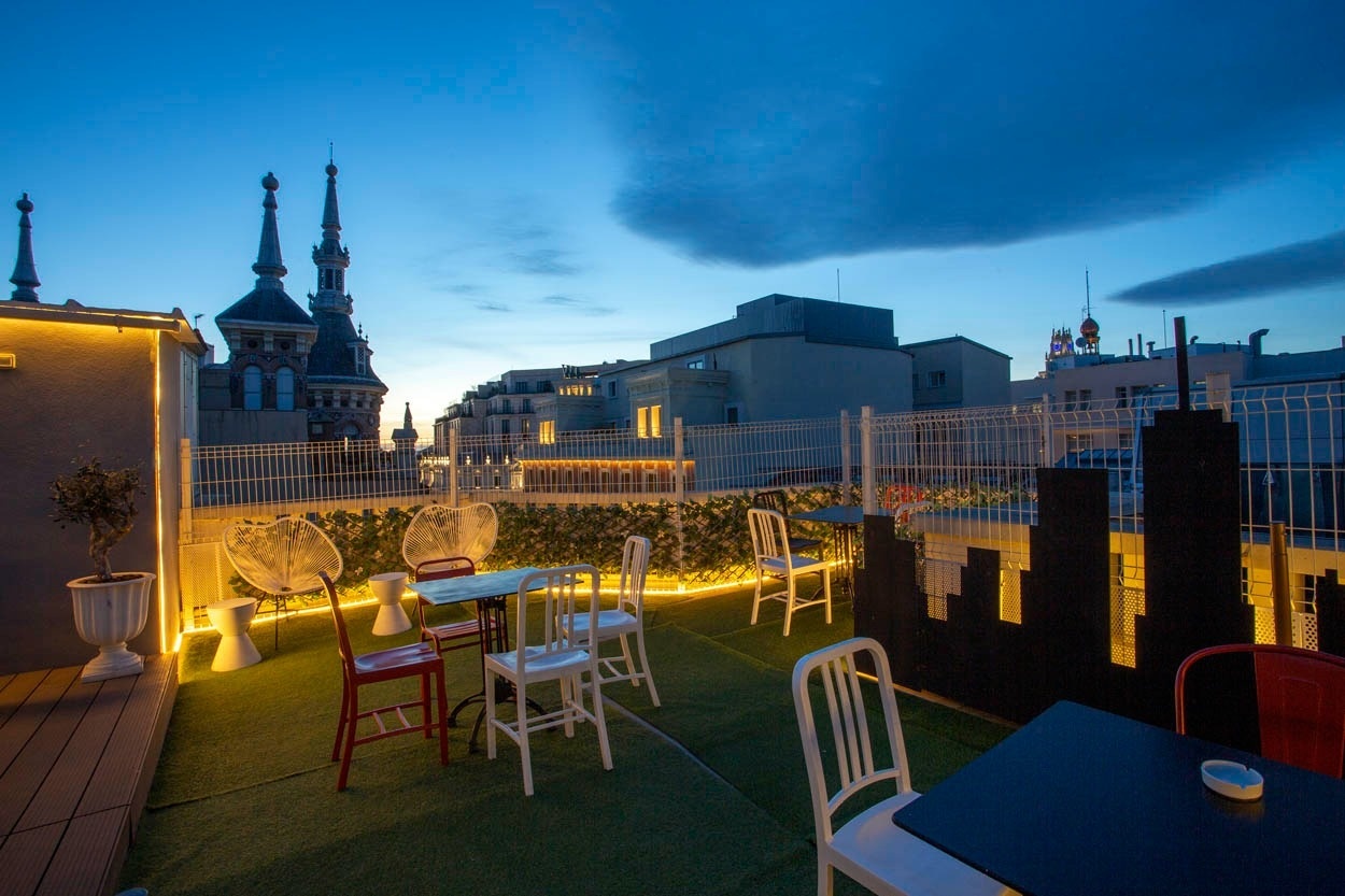 Terrasse des Casual del Teatro Madrid mit Blick auf die Skyline bei Dämmerung. Entspannter Aufenthalt.