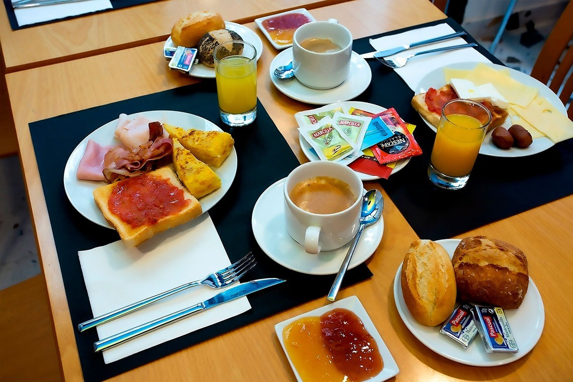 una mesa llena de platos de comida y una taza de nescafe
