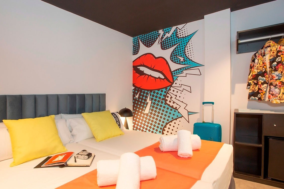 a bedroom with a pop art mural on the wall