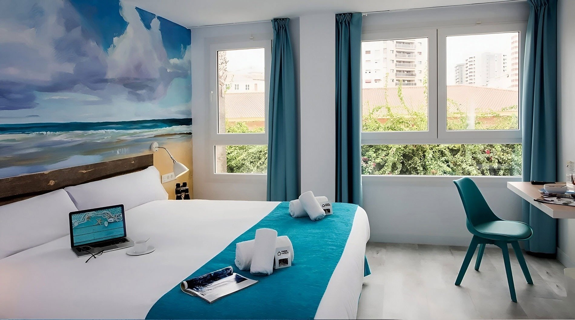 una habitación de hotel con una cama y una computadora portátil