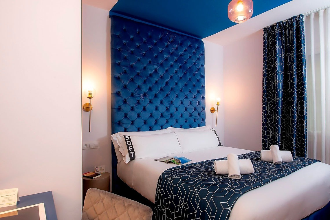 una habitación de hotel con una cama y una almohada que dice soft