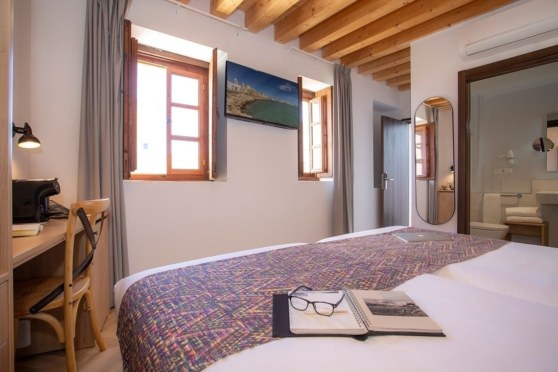 a hotel room with a bed and a laptop on it