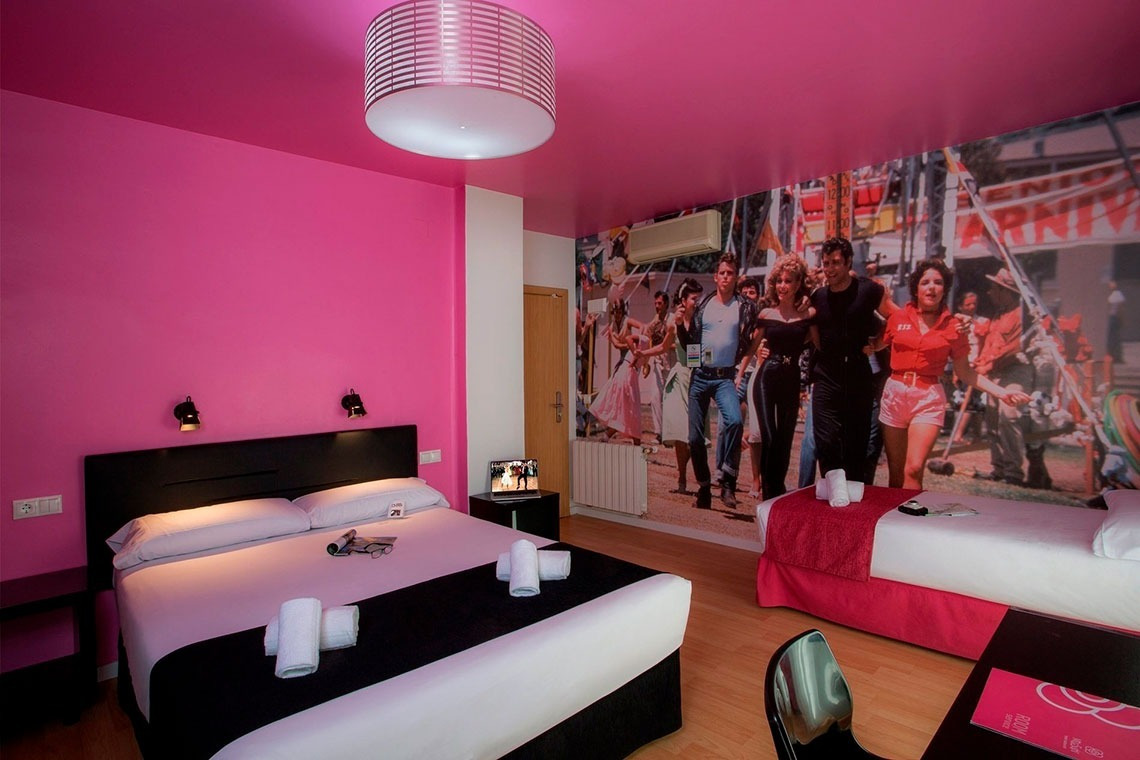 a hotel room with a picture of grease on the wall