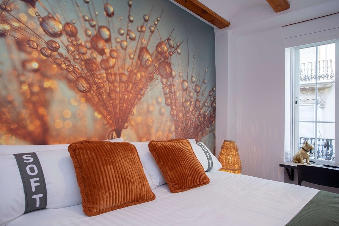 Gemütliches Schlafzimmer im Casual Natura Valencia, mit Makroaufnahme von Tropfen auf einer Pusteblume als Wandbild.