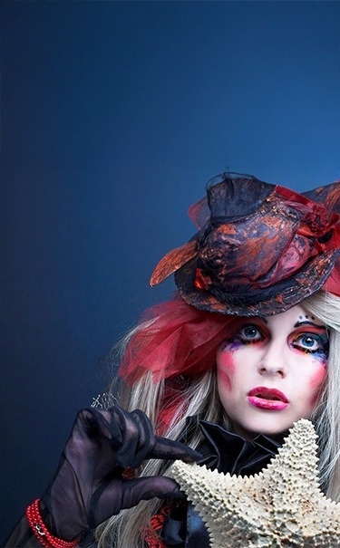 une femme vêtue d' un chapeau rouge tient une étoile de mer