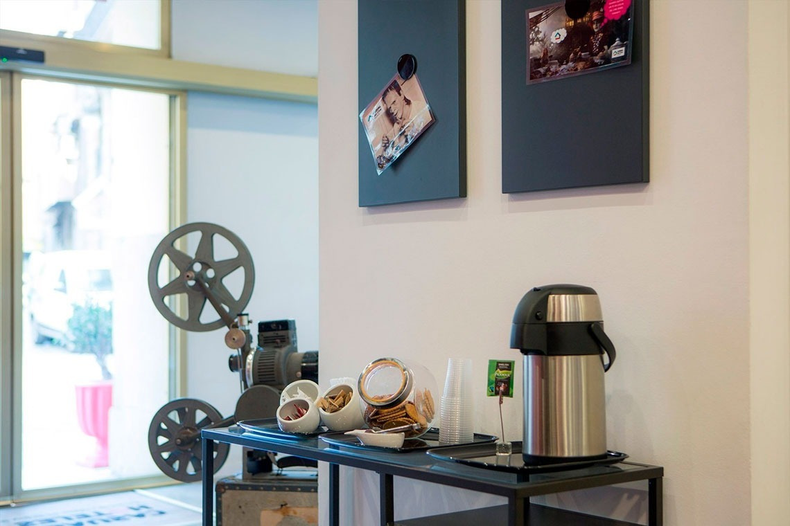 a stainless steel thermos sits on a table in front of a projector
