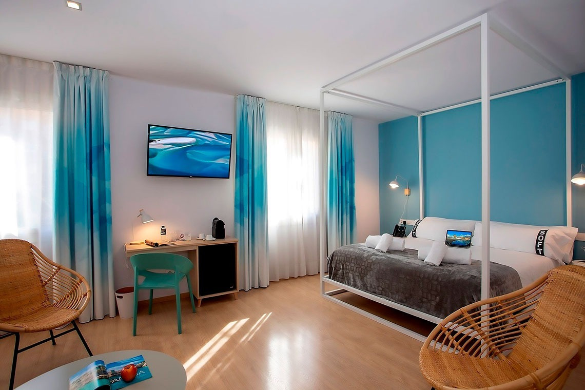 una habitación con una cama con dosel y una televisión