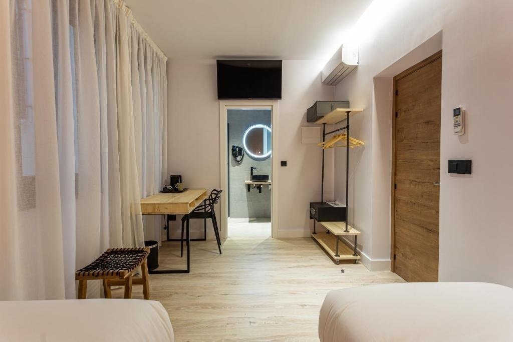 Chambre d'hôtel moderne Casual Fuentes Bilbao avec bureau et vue sur salle de bain.