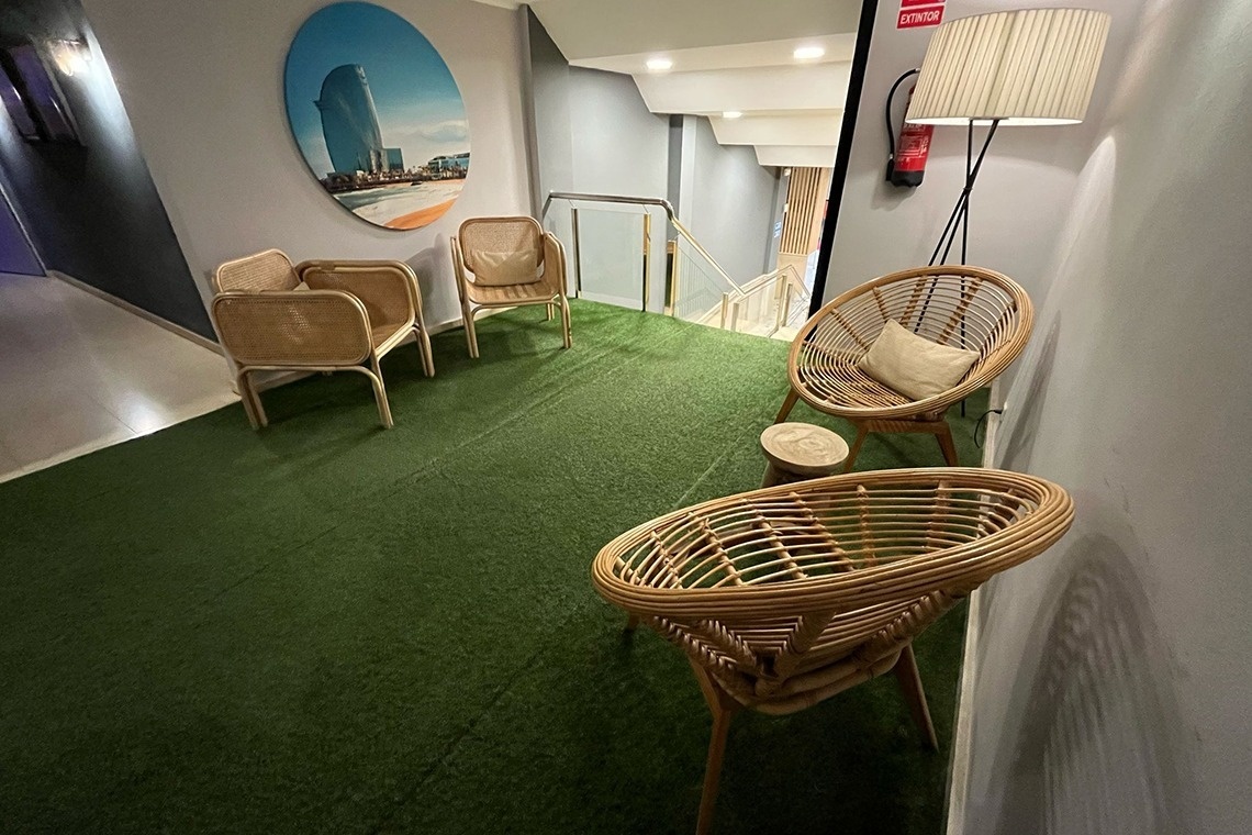 un pasillo con sillas y una lámpara y un cuadro en la pared que dice extintor