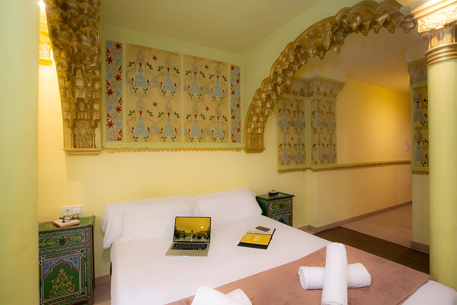 Gemütliches Schlafzimmer im Casual de las Civilizaciones, Valencia, mit Laptop und orientalischem Dekor.