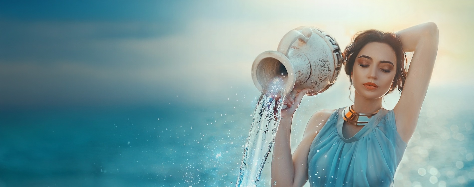 una cama llena de mantas y almohadas con un jarrón de flores en el fondo