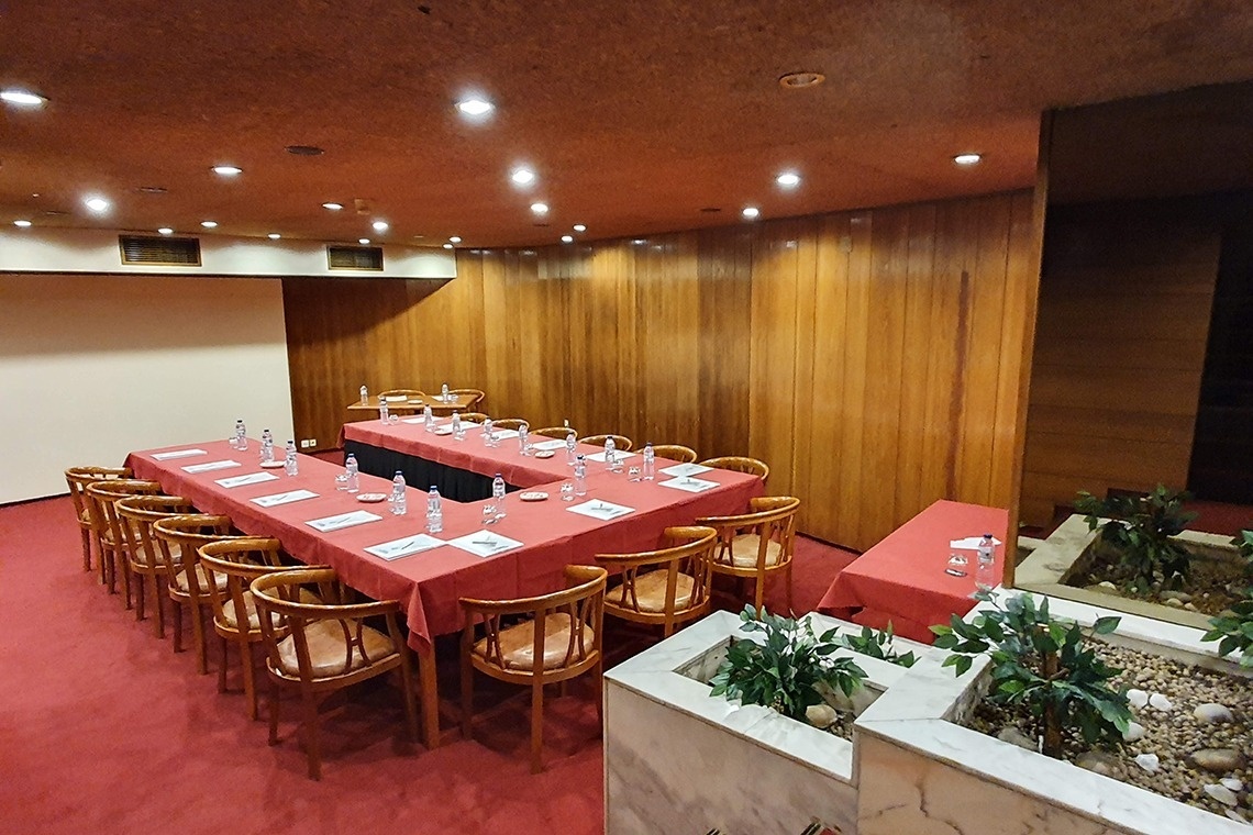 una sala de conferencias con mesas y sillas en forma de u