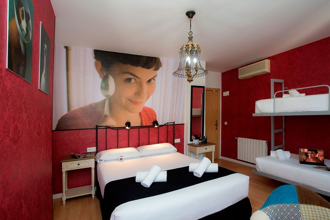 a bedroom with a picture of a woman on the wall above the bed
