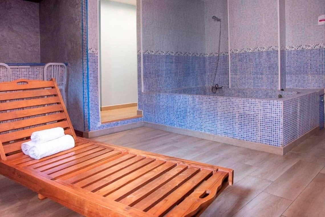 Entspannende Liege mit Handtüchern vor einer gefliesten Badewanne im Casual de las Civilizaciones - Günstiges Hotel in Valencia.
