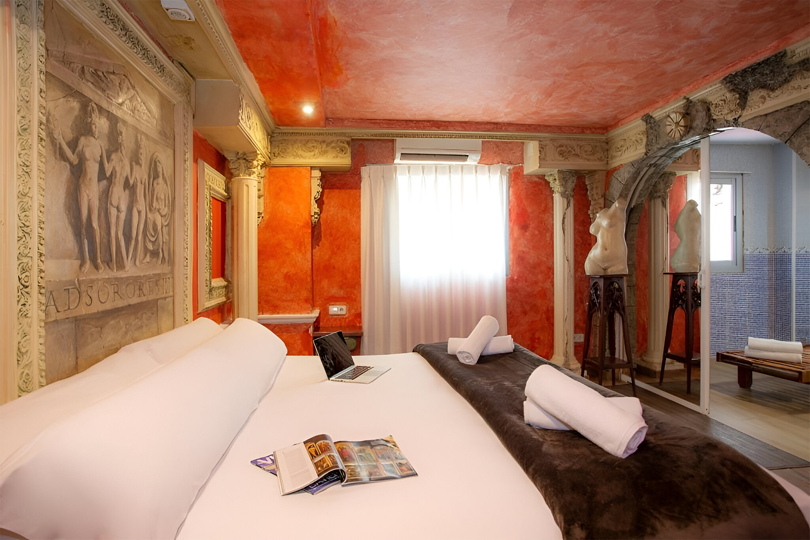 Antike Suite im Hotel Casual de las Civilizaciones: Luxuriöses Zimmer mit römischer Wandkunst und Skulpturen, ideal für einen günstigen Aufenthalt in Valencia.