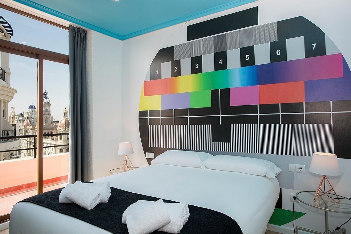 a bedroom with a television screen on the wall