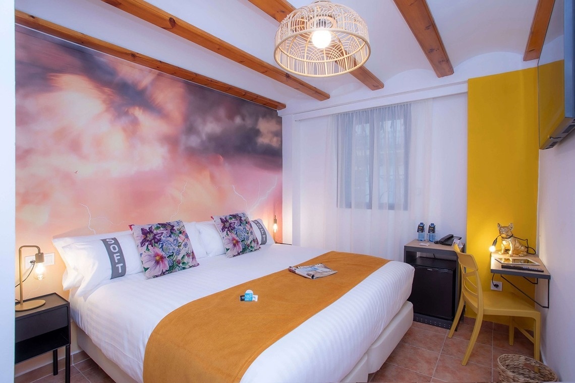 Einzigartiges Zimmer im Casual Natura Valencia mit auffälliger Wandmalerei und gemütlichem Bett.