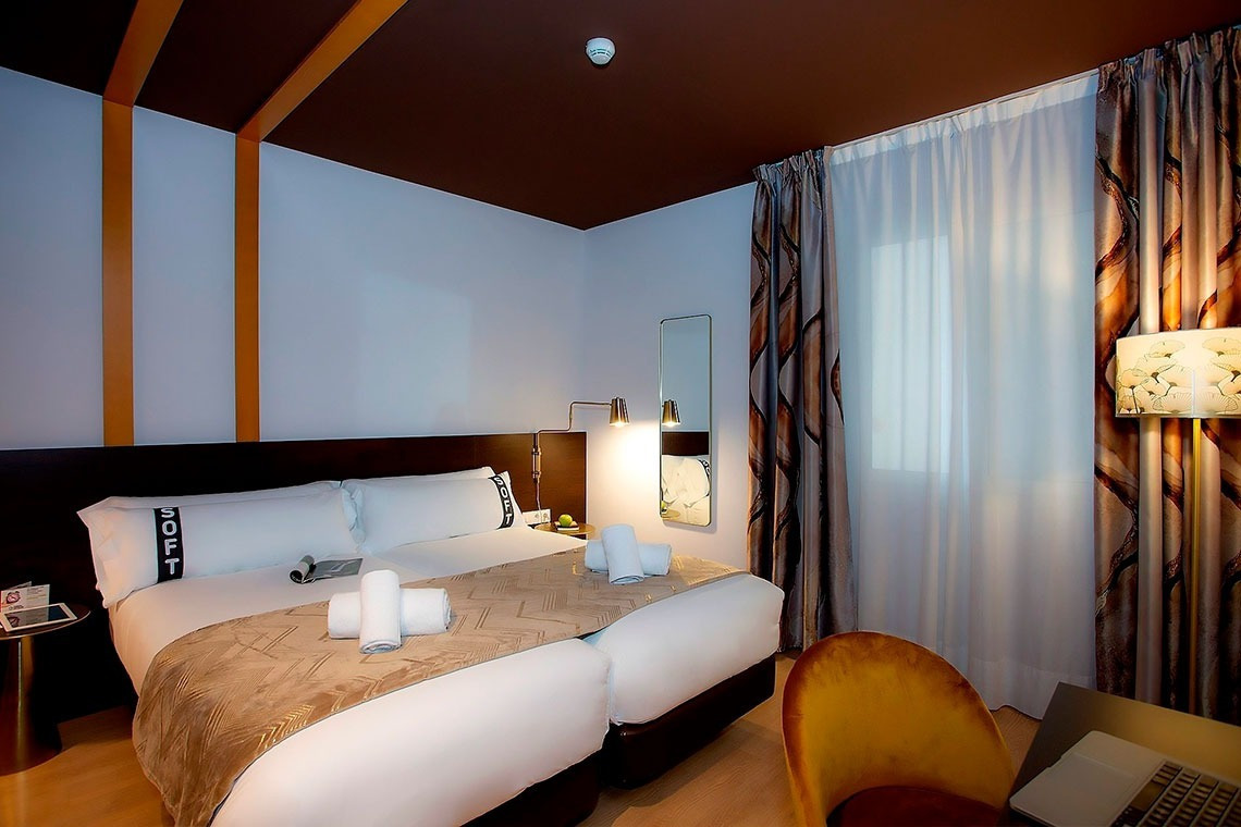 una habitación de hotel con dos camas y una silla amarilla
