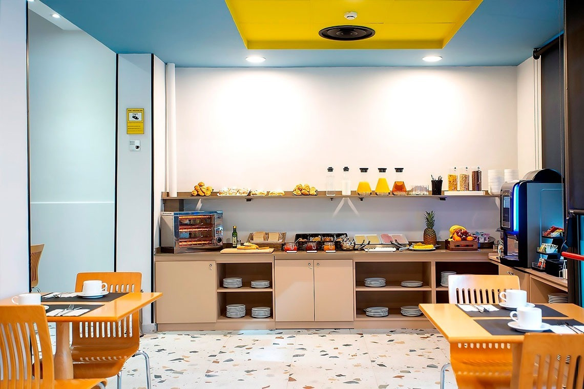 un área de desayuno con mesas y sillas