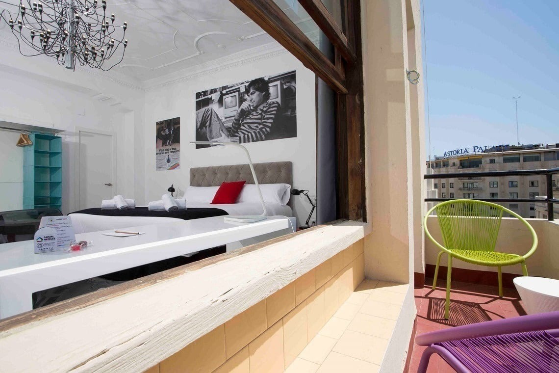 a hotel room with two beds and a green chair