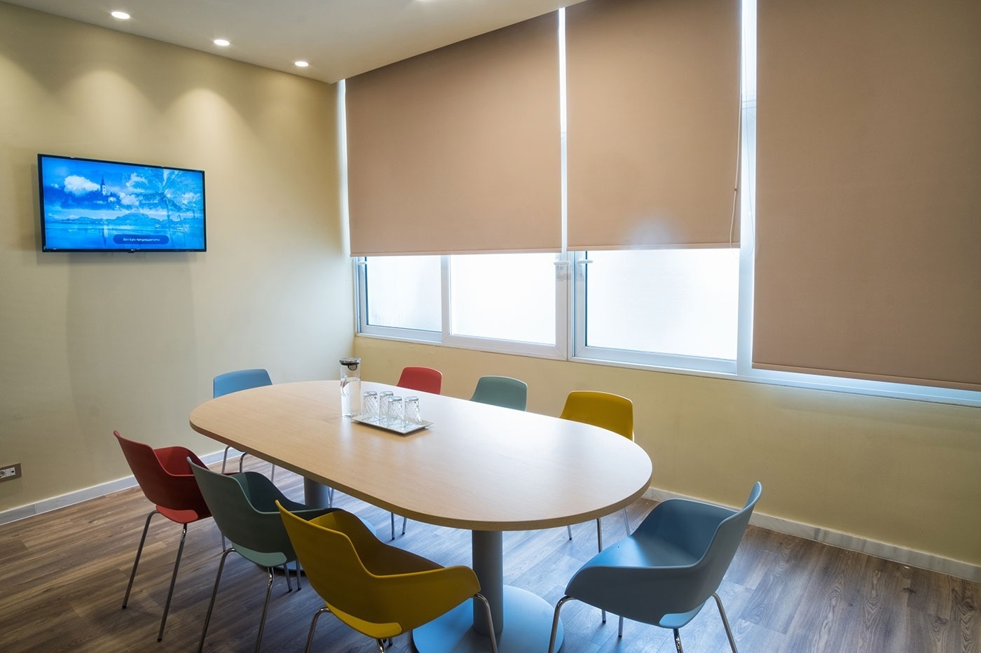 een tafel en stoelen in een kamer met een televisie aan de muur