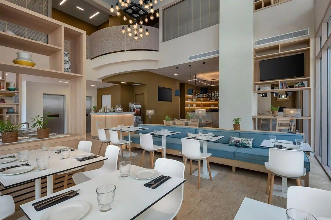 un restaurante con mesas y sillas blancas y un sofá azul