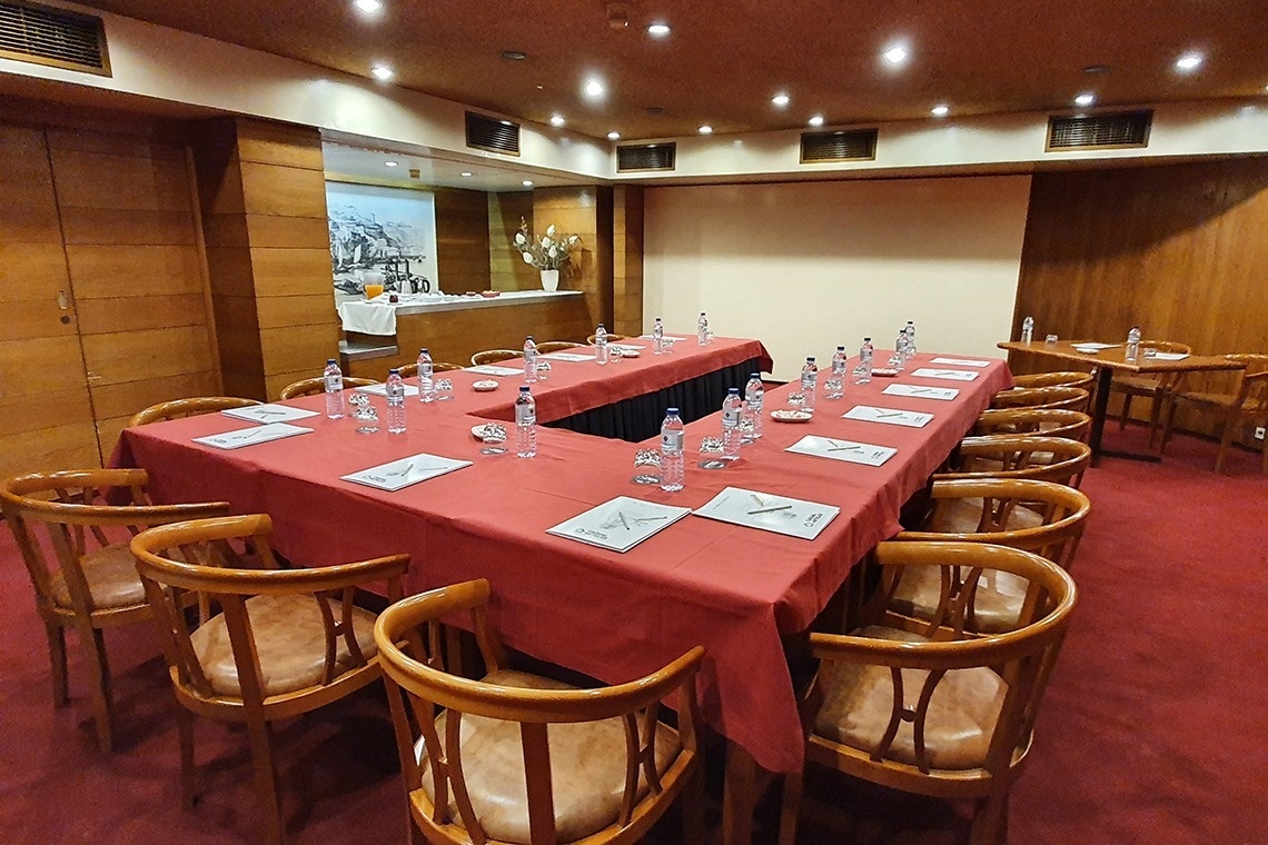 una sala de conferencias con mesas y sillas y botellas de agua