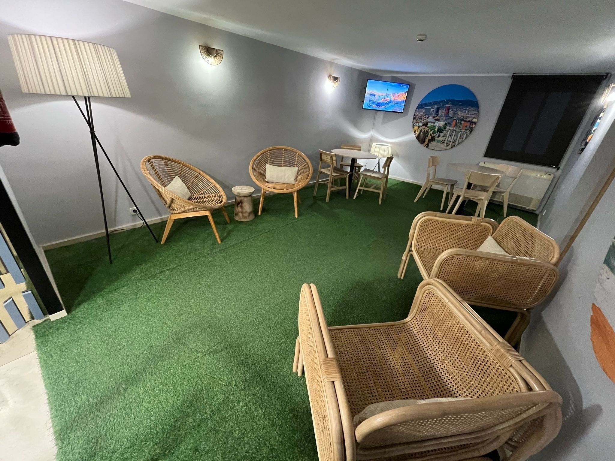 una habitación con sillas y mesas y una televisión en la pared