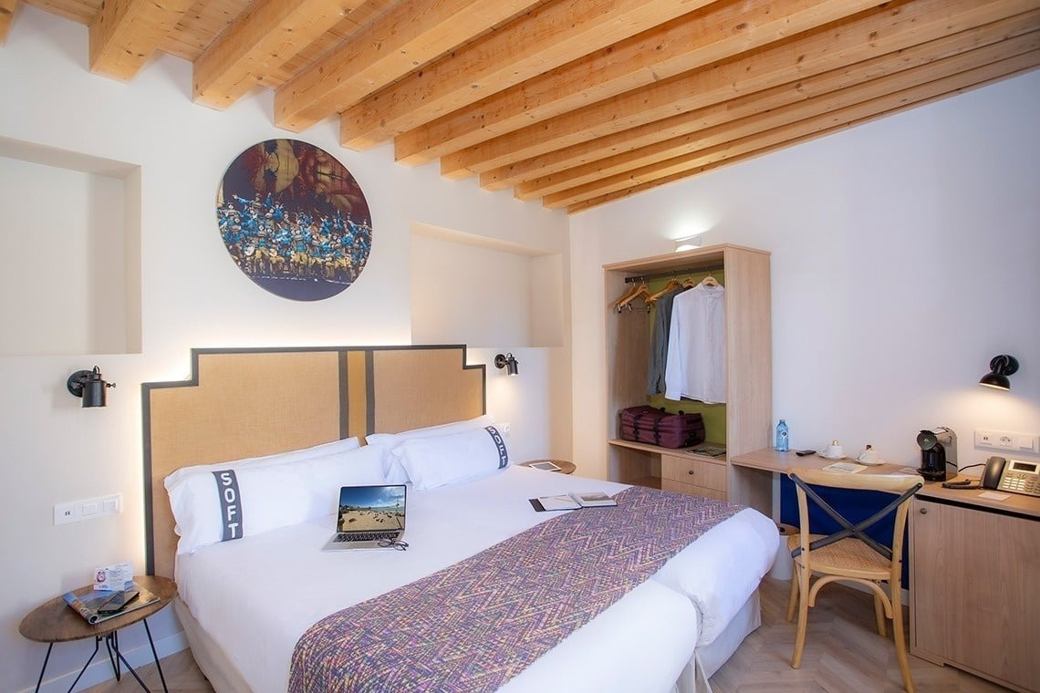 a hotel room with a bed and a laptop on the bed