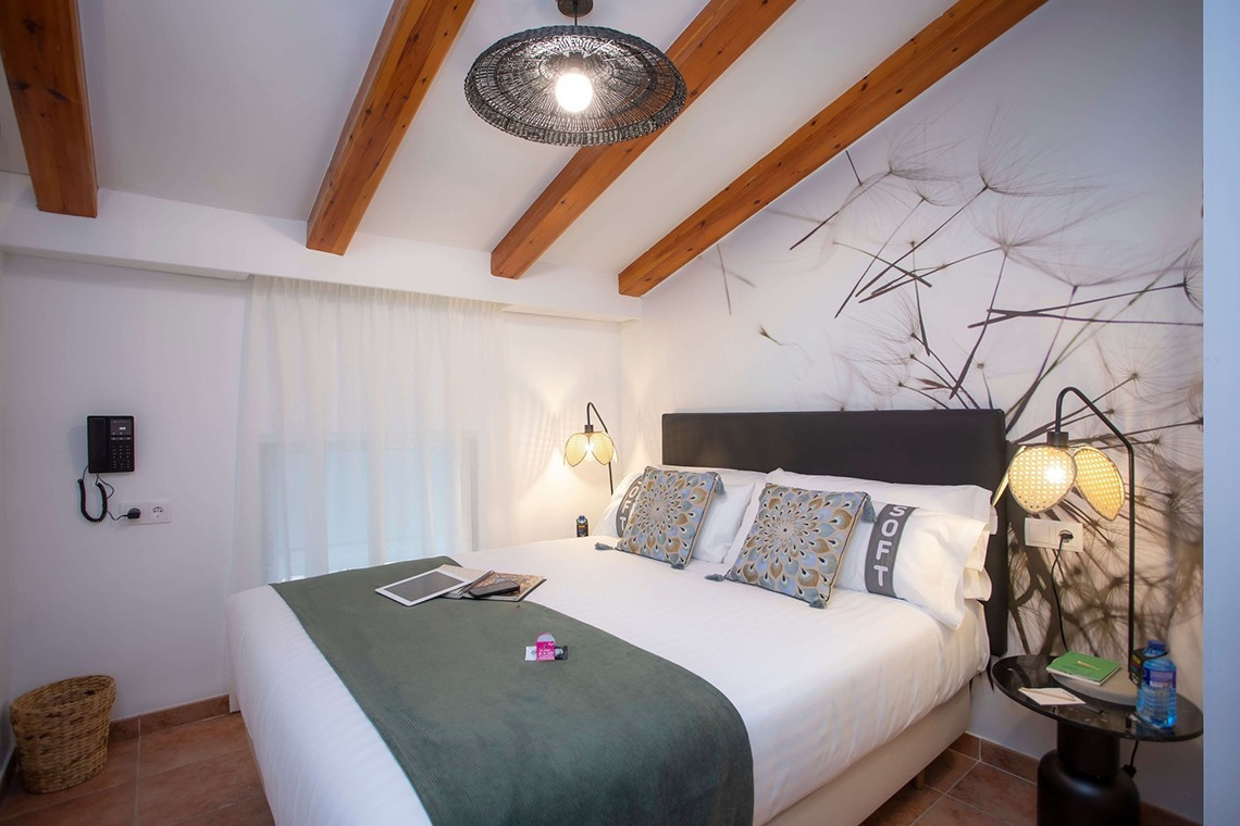 Gemütliches Schlafzimmer im Casual Natura Valencia, inspiriert von der Natur. Mit Holzbalken & Wanddeko. Casual Hoteles.