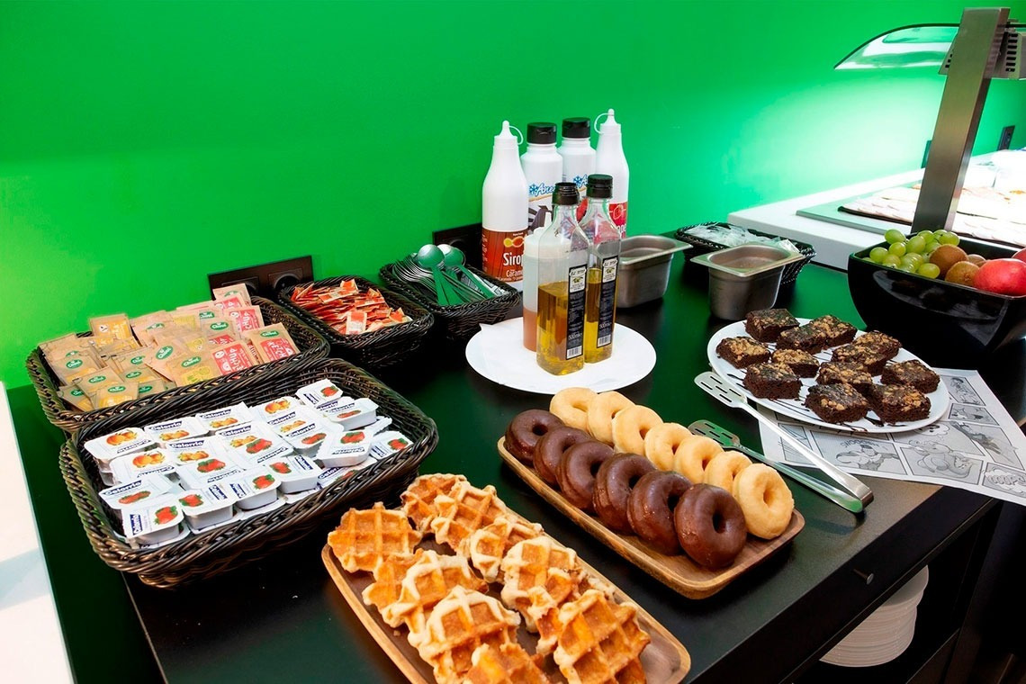 a buffet table with a variety of food including waffles and donuts
