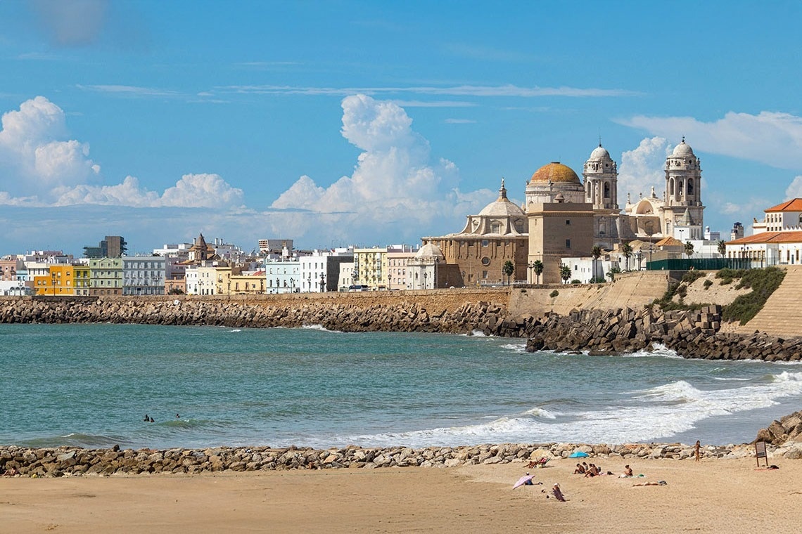 una playa con una catedral en el fondo