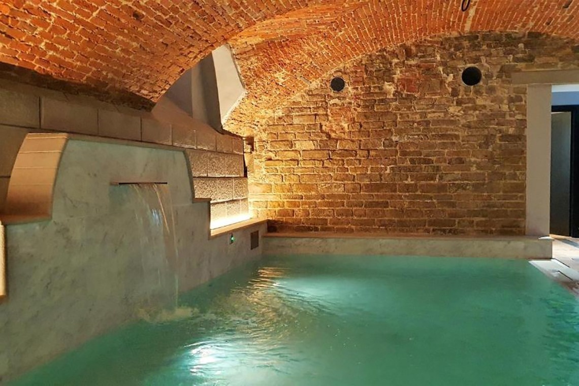 una piscina con una cascada y una pared de ladrillo