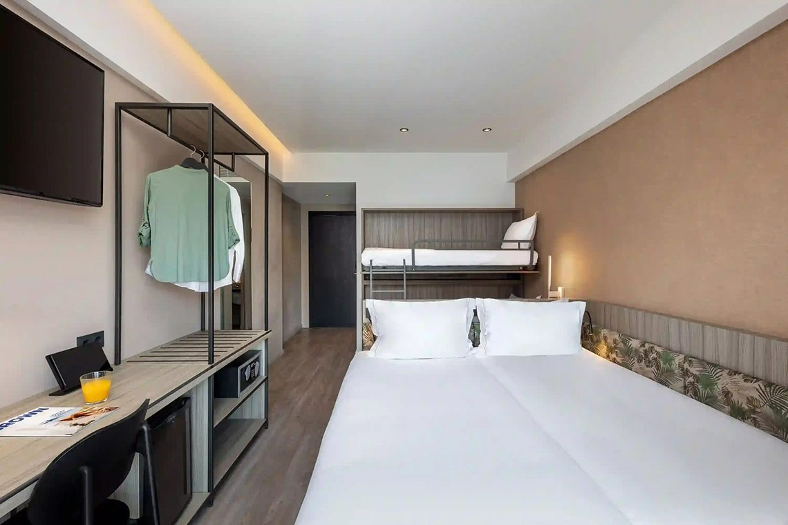 una habitación de hotel con una cama doble y una litera