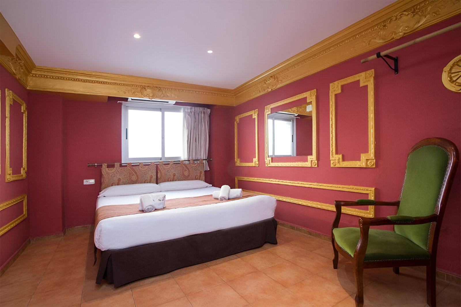 Komfortables Doppelbett in Valencia mit roten Wänden & Goldschmuck. Casual de las Civilizaciones - Günstiges Hotel.