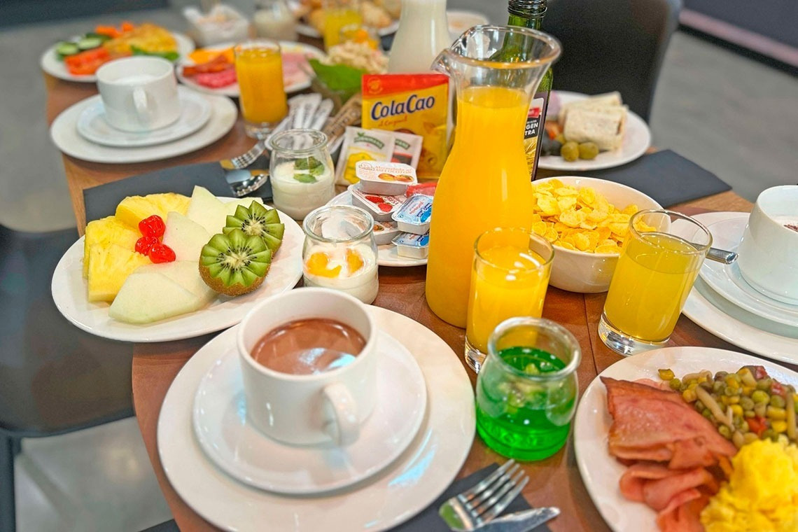 a table topped with plates of food and a bag of cola cao