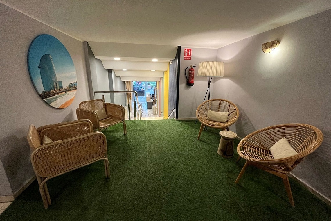 un pasillo con sillas y un extintor en la pared