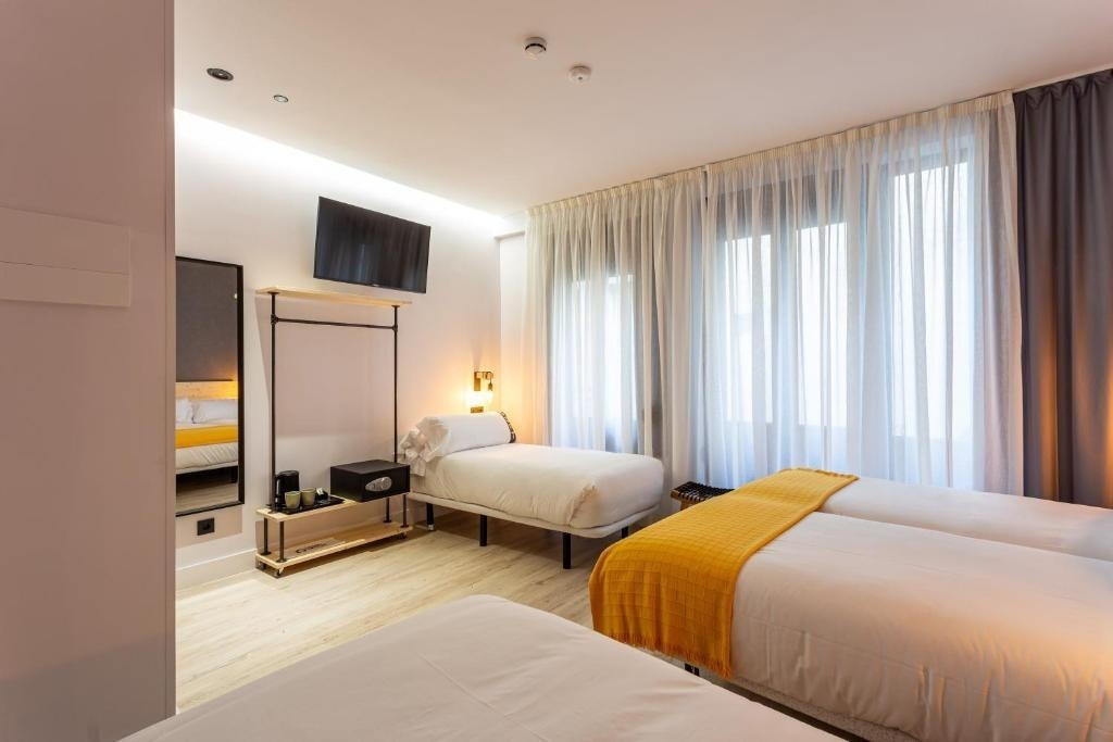una habitación de hotel con dos camas y una televisión