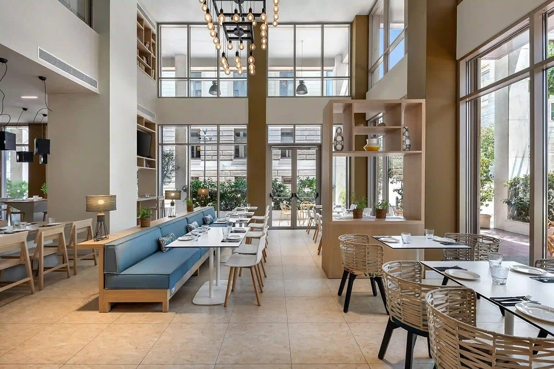 un restaurante con muchas mesas y sillas y una gran ventana