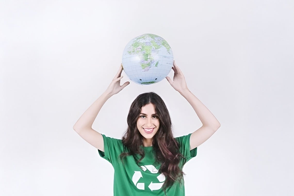 una mujer con una camisa verde sostiene un globo en sus manos