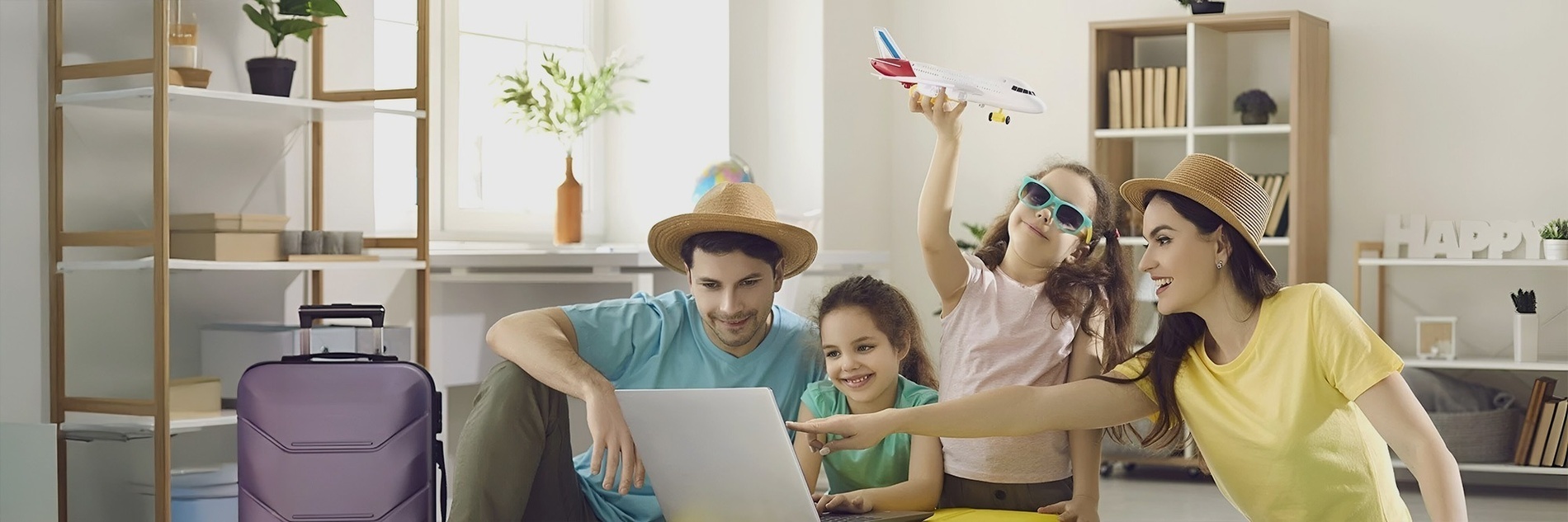 una familia mira una computadora portátil mientras un niño sostiene un avión de juguete