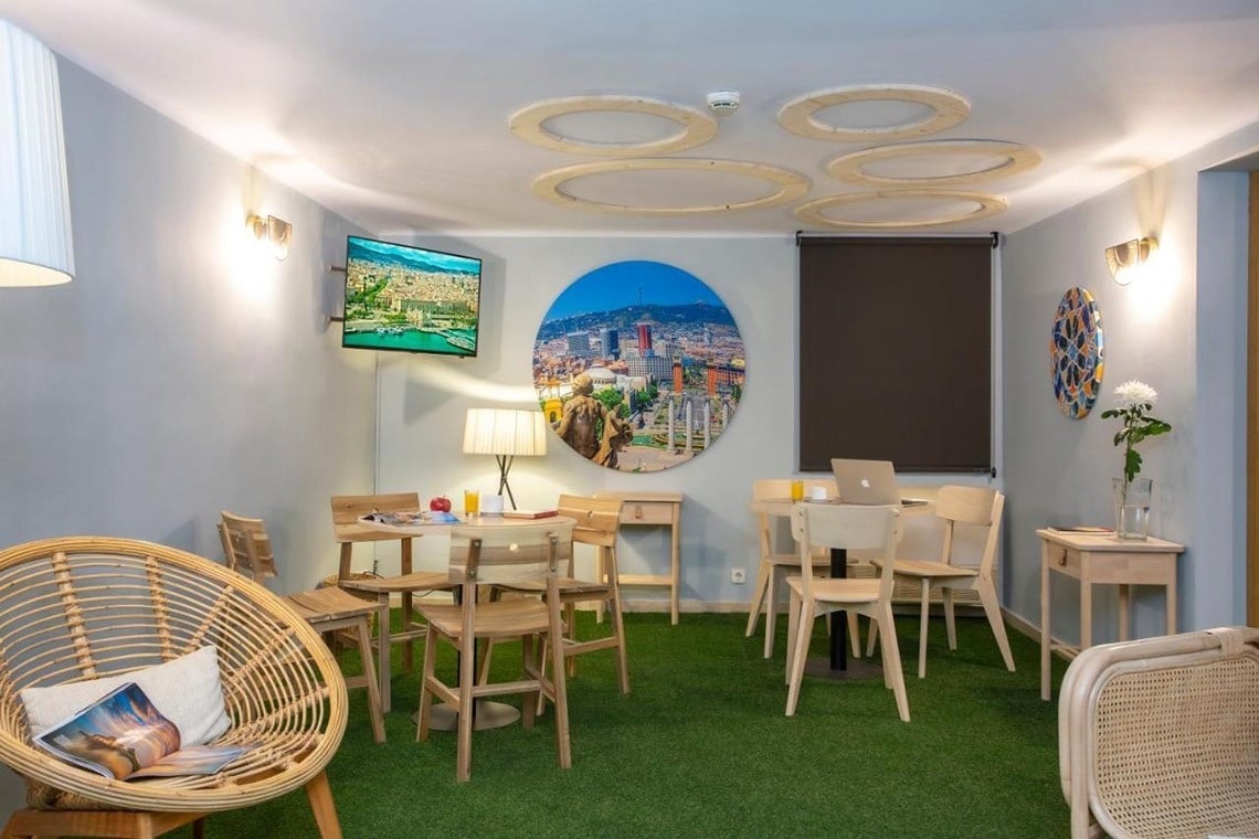 una habitación con mesas y sillas y una imagen de una ciudad en la pared