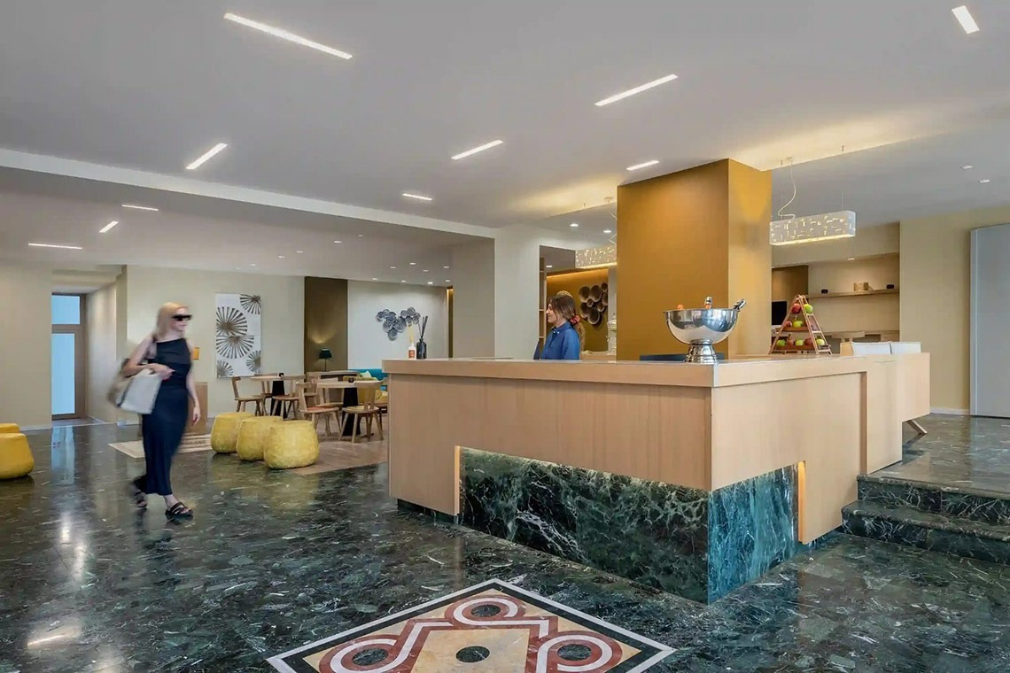 una mujer camina hacia la recepción de un hotel