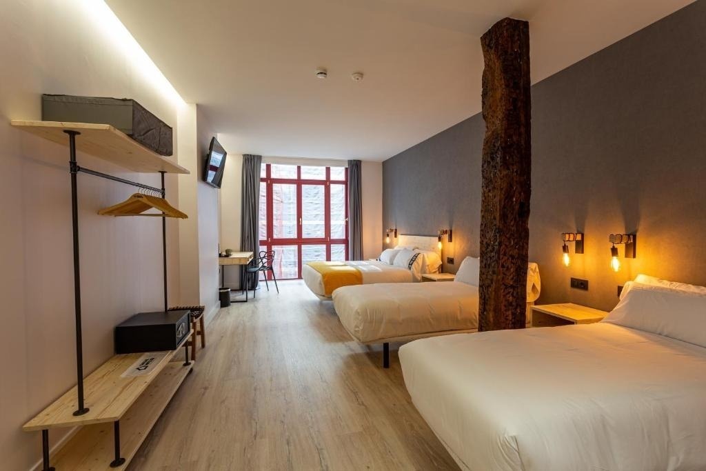 una habitación de hotel con dos camas y una ventana