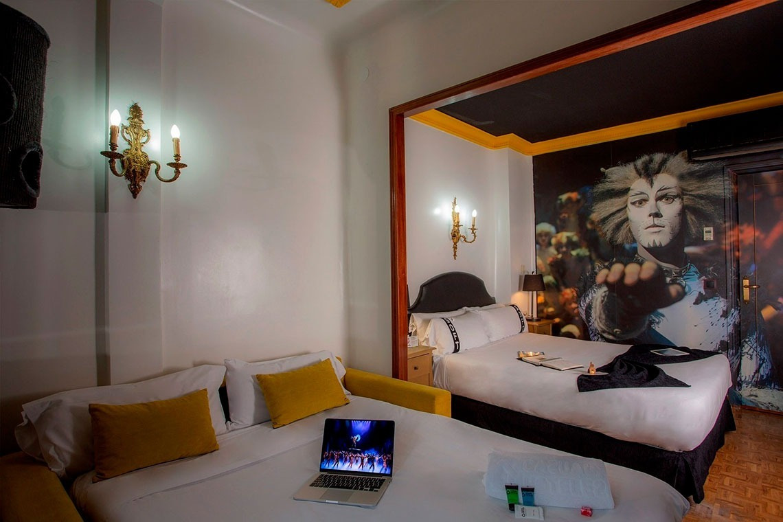 a bedroom with two beds and a laptop on the bed