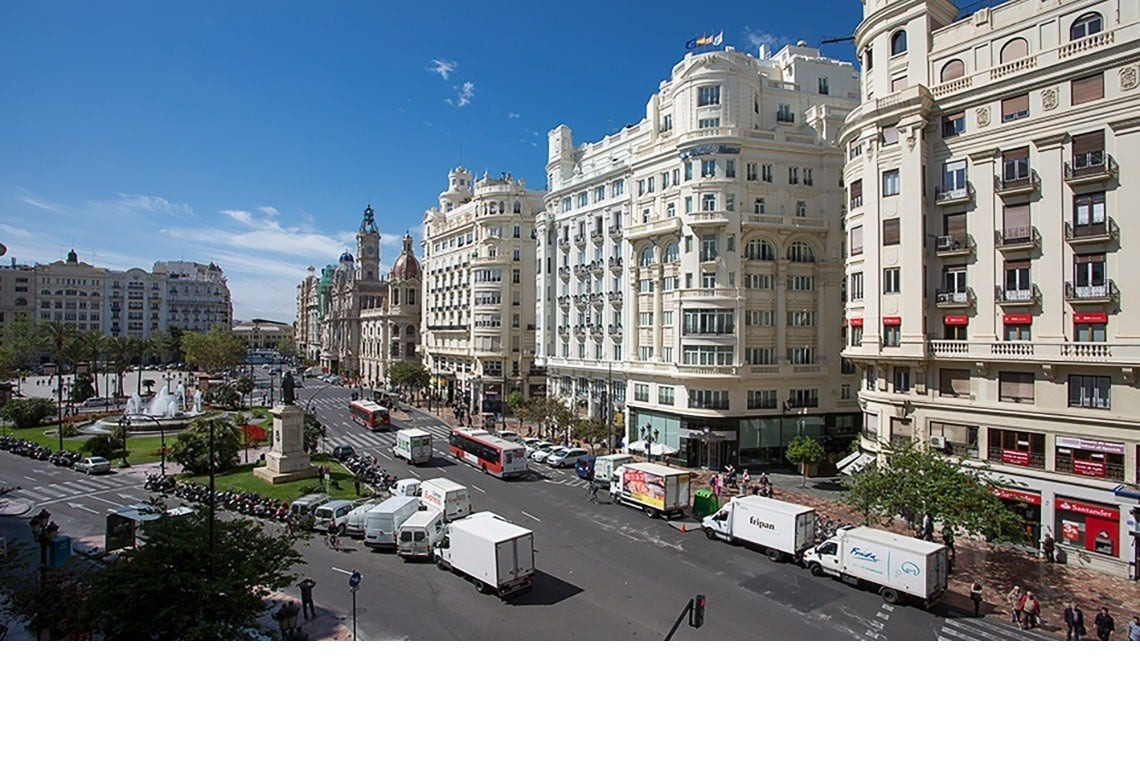 a busy city street with a few trucks including one that says ' caixa ' on it