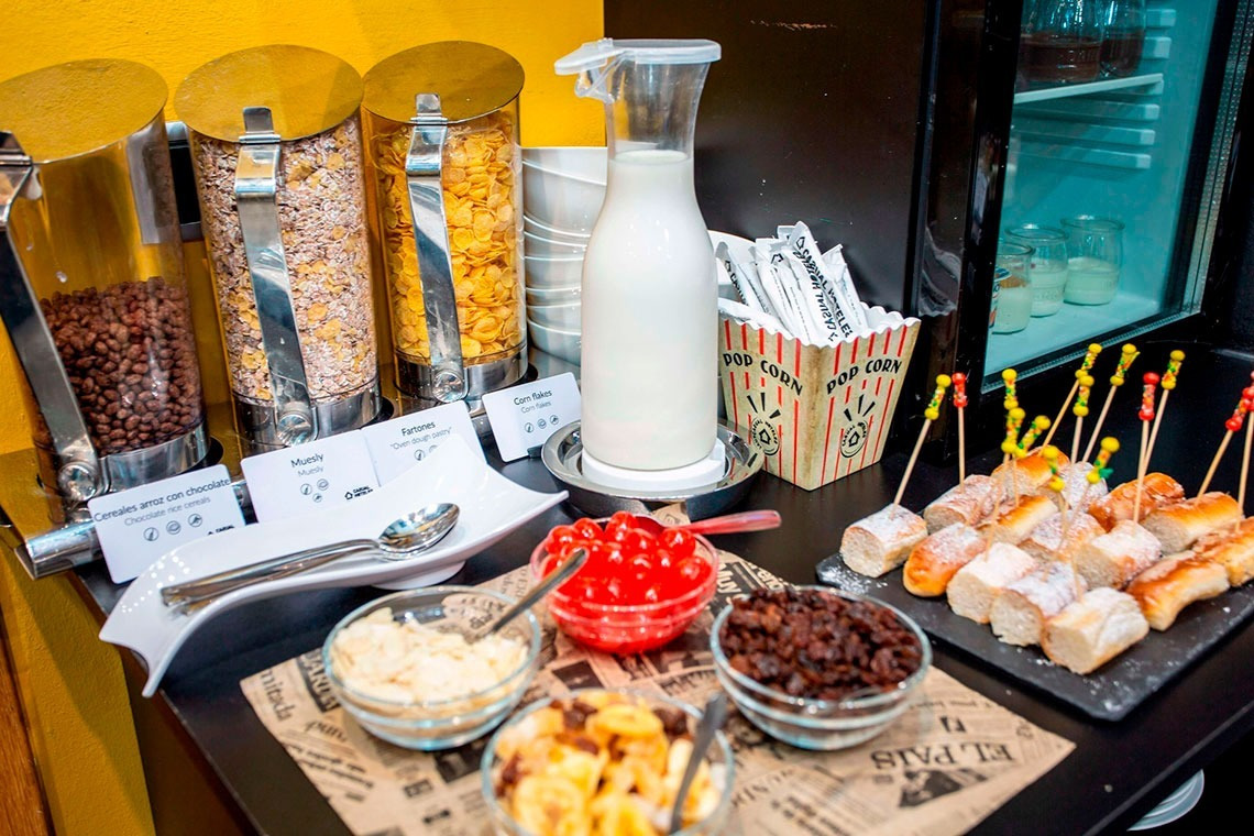 a buffet with a container of popcorn and a bottle of milk